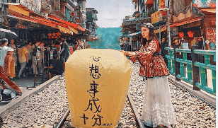 A person standing on train tracks with a large yellow lantern
Description automatically generated