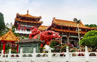 A red dragon statue in front of a building
Description automatically generated