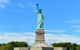 A statue of liberty with people standing around
Description automatically generated