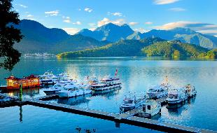 Boats on the water with mountains in the background
Description automatically generated