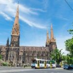 A church with a train on the street Description automatically generated with medium confidence