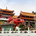 A red dragon statue in front of a building Description automatically generated