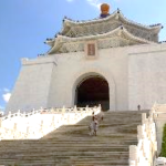 A white building with a large archway with Chiang Kai-shek Memorial Hall in the background Description automatically generated with medium confidence