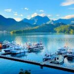 Boats on the water with mountains in the background Description automatically generated