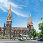 A church with a train on the street Description automatically generated with medium confidence