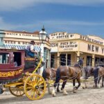 A horse drawn carriage with horses Description automatically generated