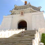 A white building with a large archway with Chiang Kai-shek Memorial Hall in the background Description automatically generated with medium confidence
