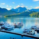 Boats on the water with mountains in the background Description automatically generated