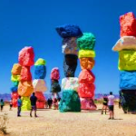 A group of people standing around stacked rocks Description automatically generated