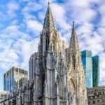 A large stone building with a tall spire Description automatically generated